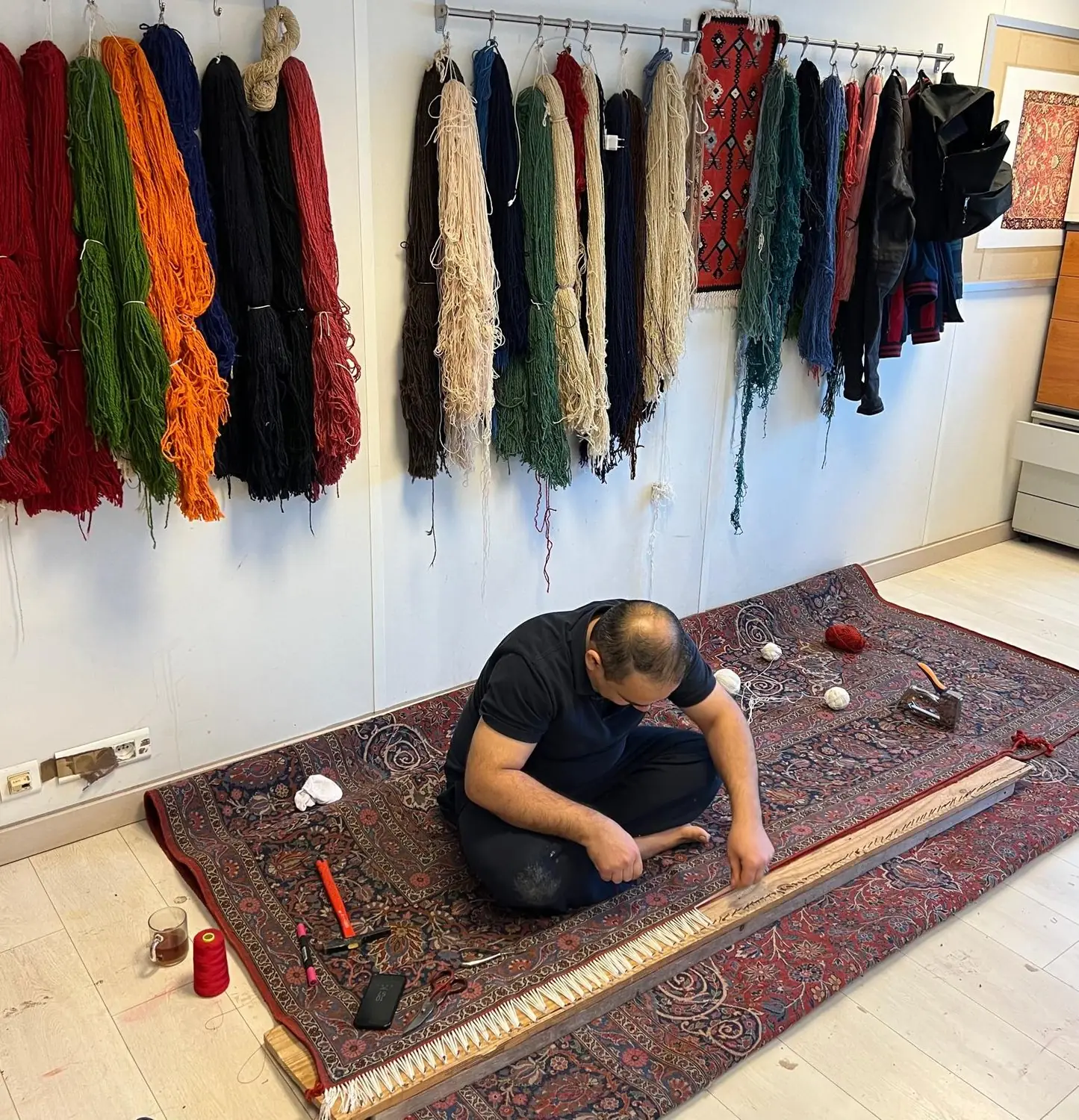 Artisan de Maison Horn au travail sur un tapis